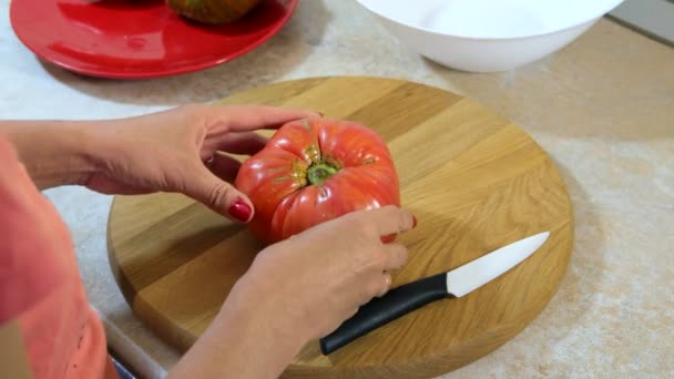 女人的手用菜刀切笨拙 多汁的西红柿在木板上切板 健康饮食 — 图库视频影像