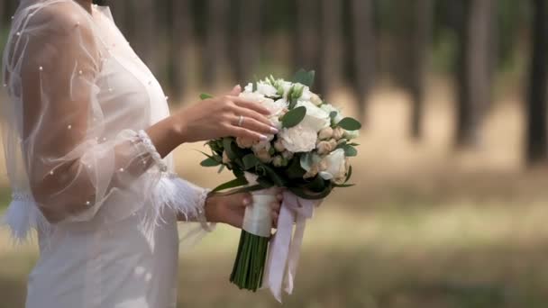 Невеста Белом Платье Приспосабливается Нюхает Свадебный Букет Роз Фоне Соснового — стоковое видео