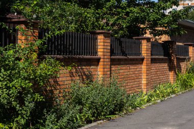 Güzel dekoratif, modern, tuğla kolonları olan ahşap çitler..