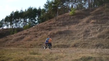 Sakallı bir baba kızına tıbbi maskeler ve bisiklet kaskıyla bisiklet sürmeyi öğretir. Covid-19 koronavirüs enfeksiyonundan korunma. 