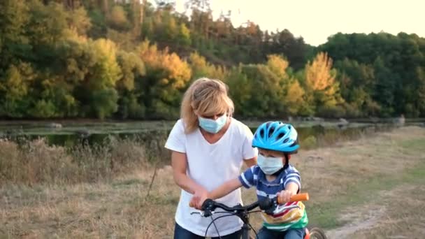 Молодая Мать Учит Сына Ездить Велосипеде Медицинских Масках Велосипедном Шлеме — стоковое видео