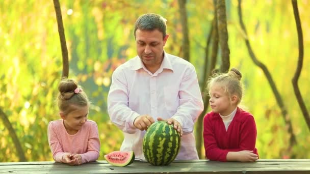 Pappa Med Två Små Döttrar Skär Vattenmelon Parken Vid Ett — Stockvideo