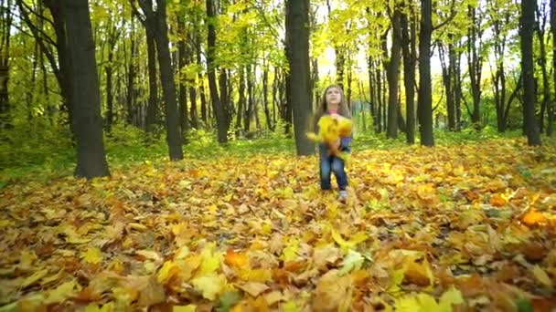 Усміхнена Дівчинка Кидає Жовте Листя Крутить Осінньому Парку Сонячний День — стокове відео