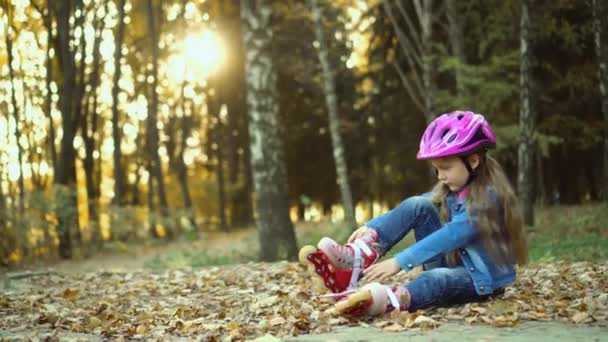 Little Girl Denim Suit Fastens Roller Skates Sitting Ground Autumn — Stock Video