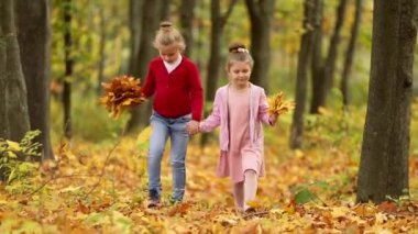 Sonbahar Parkı 'nda yürüyen iki küçük kız.