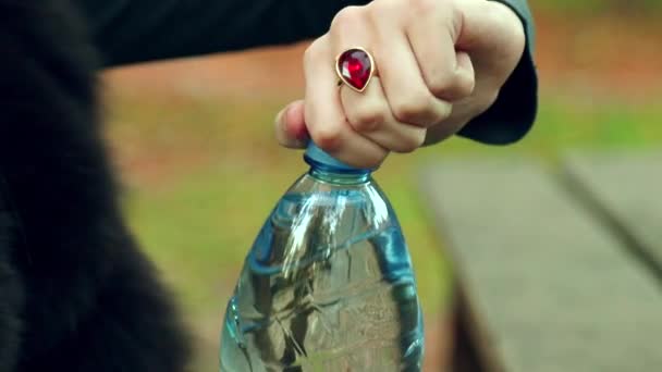 Красивая Молодая Девушка Открывает Бутылку Чистой Воды Осеннем Парке — стоковое видео
