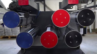 İpliği belli bir CNC kalınlığına çizme işlemine sahip extruder 'a basın. Bobindeki bir PP iplik şeridini sarmak için kullanılan makine. Polipropilen iplik kuyular arasında hareket ediyor. Şaftlar dönüyor . 
