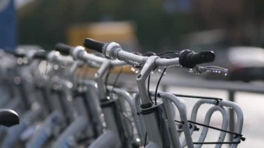 Şehir merkezinde bisiklet kiralamak için var. Yağmurdan sonra yakın çekim. Arka planda, geçen bir araç odak dışı..