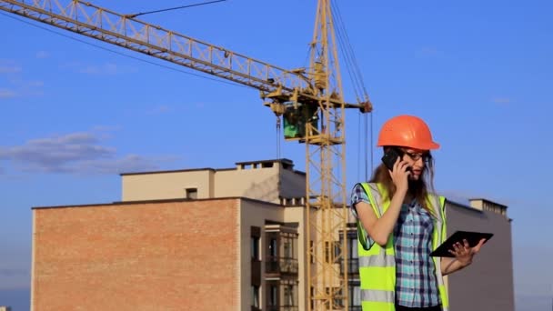 Egy Fiatal Mérnök Lány Egy Építkezésen Zöld Mellényben Narancssárga Keménykalapban — Stock videók