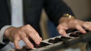 Piyano tuşlarında klavye sentezleyicisi çalan müzisyen. Müzisyen konser sahnesinde bir müzik aleti çalar. Kapatın. Bir müzik aleti arka planı. 