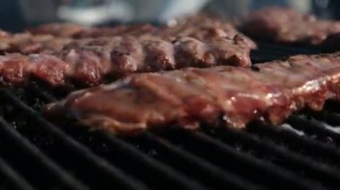 Kaburga pişirmek için büyük elektrikli ızgara. Pirzolalar dönüyor ve festival sokak yemeklerinde pişiriliyor. Et kendi ekseni etrafında bir şiş üzerinde döner.