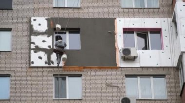 Yüksek erişimli kazıcı kıskaçları ev duvarını yıkıyor. Kazıcının hidrolik kolu bir eve çarpıyor ve yıkıyor.