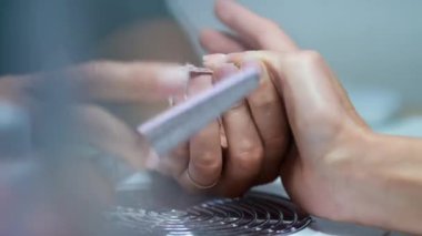 Usta manikür yapıyor. Bir tırnak testeresi. Güzel manikür yakın plan..