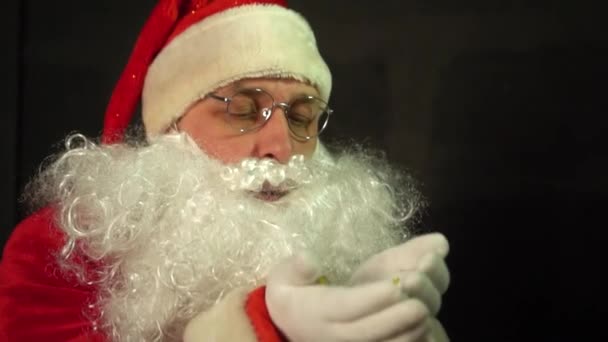 圣诞老人慢吞吞地从手上吹着闪光 — 图库视频影像