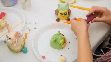 Çocuk oyun oynuyor ve kilden oyuncaklar yapıyor. Çocuğun hayal gücünü güçlendir. Baykuş kapanışı