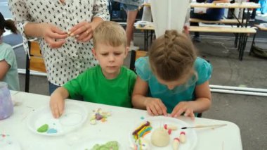 Çocuk Yaratıcılık Festivali 'nde kız ve erkek renkli bir oyun hamuru oluşturuyorlar. Çocuğun hayal gücünü güçlendir..