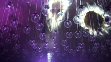 Tavanın altında bir sürü yuvarlak avize ve lamba var. Işık gösterisi lambaları karanlık moda iç mekan, aydınlatma ve iç mekan konsepti.