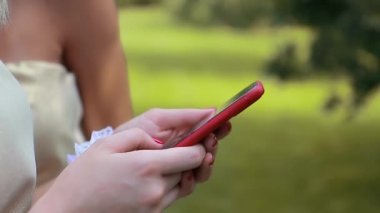 Kız elleri akıllı telefona dokunuyor. Parlak arkaplan, yakın plan.