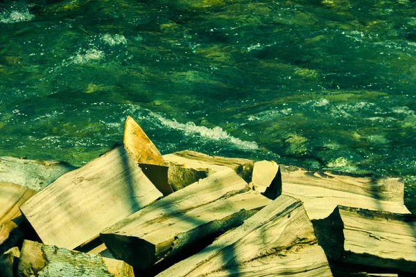 Firewood on the banks of the mountine river — Stock Photo, Image