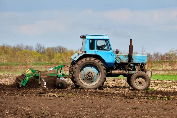 Een tractor op het veld plantaardige aardappelen en cultiveert de grond, het planten van aardappelen met een kleine trekker — Stockfoto