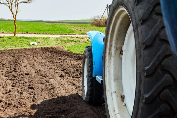 Een tractor op het veld plantaardige aardappelen en cultiveert de grond, het planten van aardappelen met een kleine trekker — Stockfoto