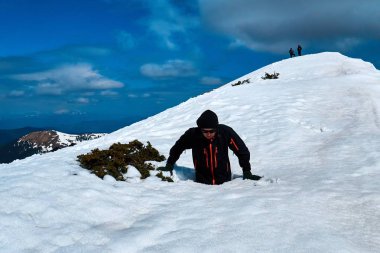 turist güzel bir manzara ile dağın tepesinde kar içine düşüyor , kış dağlarında kar boyun