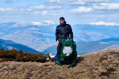 karla kaplı bir dağın tepesinde turist dağcı