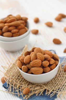 Masanın üzerinde bir kasede badem fındık