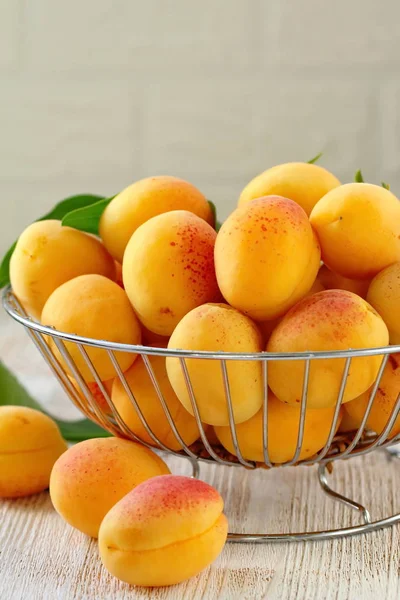 Olgun tatlı taze kayısı ahşap masa üzerinde bir sepet içinde