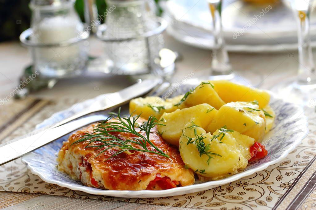 Fillet of red fish baked with tomato, greens and cheese served with boiled potatoes