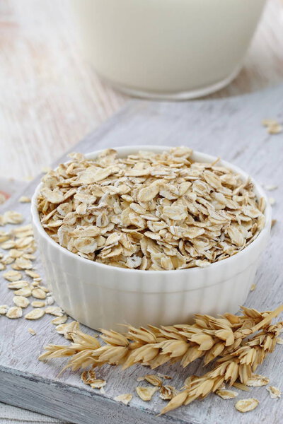 Овсяные хлопья в стакане и кувшин молока на здоровый завтрак
