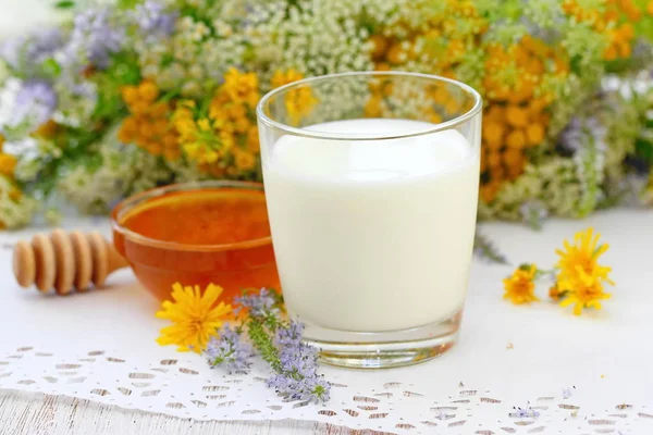 Glas Mjölk Och Färsk Honung Skål Med Blommor Bakgrund — Stockfoto