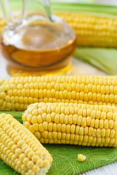 Corn oil and corn cobs on the table