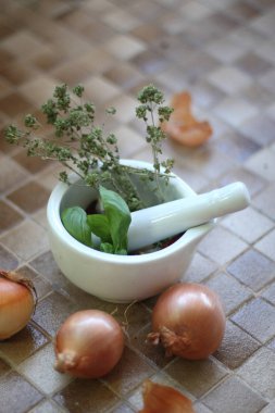 Yeşil fesleğen ve soğan üzerinde beyaz bir kase cam masa 