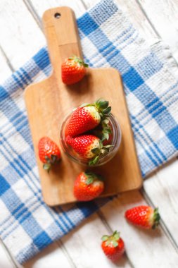 Doğal ışık ile ahşap bir gemide taze kırmızı çilek.