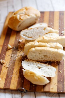 Ahşap kesme tahtası üzerinde ekmek dilimlenmiş 