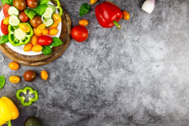 Salata yapmak için taze organik malzemeler: avokado, domates, arka planda fesleğen, üst manzara. Metin için yeri olan düz bir yatak. Vegan ve sağlıklı gıda konsepti