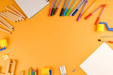 Turuncu arka planda çeşitli okul malzemeleri tasarımınız için hazır. Okul konseptine dönelim..