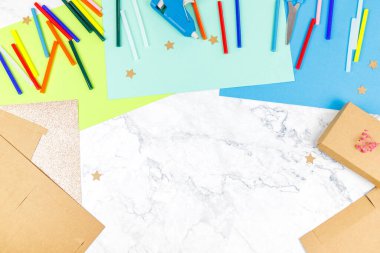 Bay Masa 'nın üstündeki el işi eşyalarının üst görüntüsü. Kağıt çarşaflar, sıcak yapıştırıcı ve kalıplar..