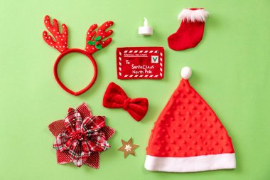 Yukarıdan görülen yeşil arkaplandaki Noel nesneleri koleksiyonu