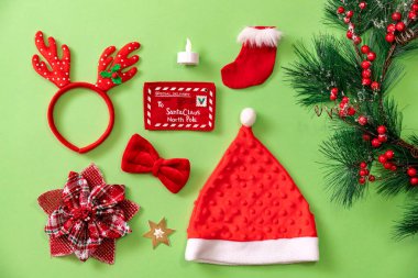 Yukarıdan görülen yeşil arkaplandaki Noel nesneleri koleksiyonu