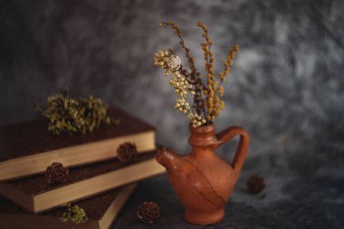 Güzel sanatlar konsepti. Gri arka planlarda çiçekli ve küresi olan taşralı kitaplara sahip natürmort yaşam.