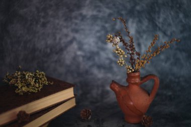 Güzel sanatlar konsepti. Gri arka planlarda çiçekli ve küresi olan taşralı kitaplara sahip natürmort yaşam.