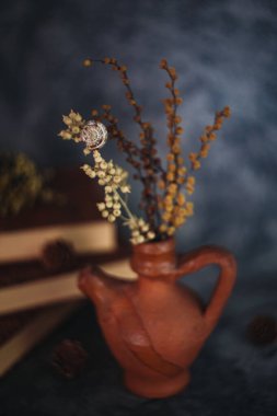 Güzel sanatlar konsepti. Gri arka planlarda çiçekli ve küresi olan taşralı kitaplara sahip natürmort yaşam.