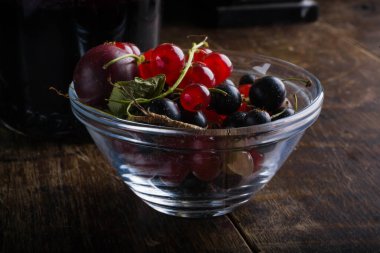 Eski ahşap masada üzümlü cam bardak.