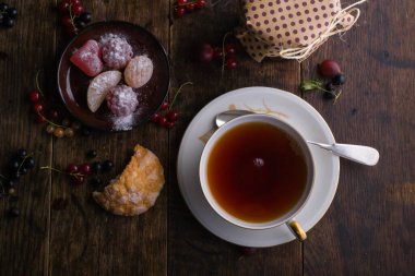 Yaz kahvaltısı. Altın süslemeli bir fincan çay ve üzerinde böğürtlenlerin bulunduğu eski ahşap masada bulunan marmelatı düşündüm.