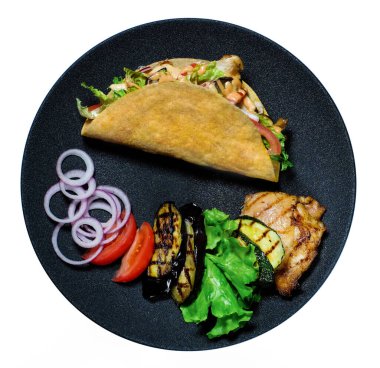 Kızarmış tavuk eti ve sebzeli taco. Siyah tabak izole edilmiş. Meksika fast food 'u. Düz yatıyordu