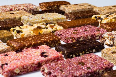 Mısır gevreği ve beyaz arka planda fındıklı protein barları ve kuru meyve meyveleriyle kompozisyon. köşegen