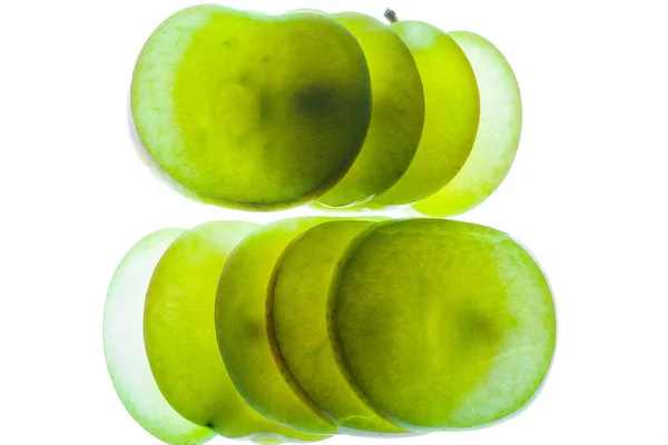 Slices of apple at the backlight isolated on a white background, macro photo — Stock Photo, Image