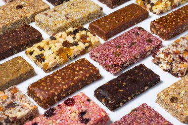 Mısır gevreği ve beyaz arka planda fındıklı protein barları ve kuru meyve meyveleri ile kompozisyon